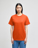 An orange short-sleeve t-shirt on a model, featuring a logo on the sleeve.