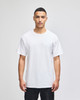 A white short-sleeve t-shirt worn by a model, featuring a simple design and a logo.