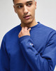 A blue Champion adult short-sleeve t-shirt with a logo, displayed on a model.