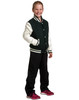 A girl wears a green and cream wool blend varsity jacket with black pants and pink sneakers, smiling confidently.