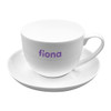 A white tea cup with a matching saucer, featuring a logo in purple on the cup.