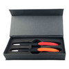 A gift set featuring two black pens with red and orange accents in a sleek grey box.