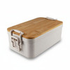 A bamboo lunch box with a light grey base and a wooden lid, featuring clips on the sides.