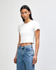 A white cropped fitted T-shirt on a model, paired with light blue jeans, featuring a logo.