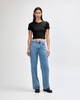 A black crop fitted T-shirt paired with light blue wide-leg jeans, displayed on a model against a plain background.