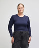 A fitted women's long sleeve crop t-shirt in navy blue, paired with high-waisted black pants. The shirt has a logo.