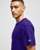 A purple Champion Adult Jersey Short Sleeve T-Shirt worn by a model, featuring a small logo on the sleeve.