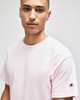 A pink Champion Adult Jersey Short Sleeve T-Shirt featuring a logo on the sleeve.