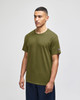 A green Champion adult jersey short sleeve T-shirt displayed on a model, featuring a logo on the sleeve.