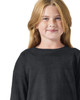 A young girl wears a black long sleeve t-shirt. The shirt has a simple, casual design and features a logo.