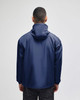 A navy blue packable anorak jacket featuring a hood and a logo on the back. Suitable for rain protection.