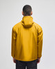 A packable anorak jacket in a vibrant yellow colour, featuring a hood and a minimalistic design.