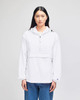 A white packable anorak jacket with a hood and a front pocket, featuring a logo. Model is wearing blue jeans.