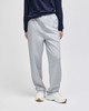 Light grey open-bottom fleece pants with pockets, featuring a relaxed fit and worn with a navy top and white shoes.