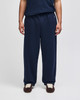 Navy open-bottom fleece pants with pockets, featuring a logo, displayed on a model.