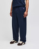 A pair of navy open-bottom fleece track pants with pockets, featuring a logo on the side.