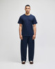 A model wears navy Champion Powerblend® adult open-bottom fleece pants with pockets, paired with a matching t-shirt.