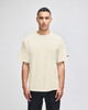 A beige Champion Adult Heritage Jersey T-Shirt displayed on a model, featuring a simple design and short sleeves.
