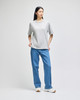 A grey Champion Adult Heritage Jersey T-Shirt worn with blue jeans, featuring a casual style and relaxed fit.