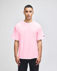 A pink Champion Adult Heritage Jersey T-Shirt displayed on a male model, featuring a logo on the sleeve.