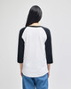 A white and black Champion Adult Raglan Baseball T-Shirt viewed from the back, featuring three-quarter length sleeves.