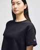 A black cropped short sleeve jersey t-shirt with a logo on one sleeve.
