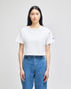 A cropped white T-shirt with short sleeves and a logo on the sleeve, paired with blue jeans.