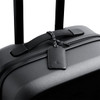 A black suitcase featuring a sleek leather luggage tag with a braided attachment. It has a minimalist design and a logo.