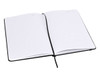 An A5 notebook with a black cover and blank lined pages, opened to display its interior.