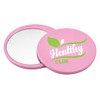 A pink circular makeup mirror with a reflective surface and a logo featuring green design elements.