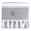 A grey towel with white fringes and a logo in the centre.