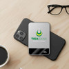 A silver MagSafe wireless power bank resting on a black phone, beside a coffee cup and glasses.