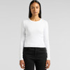 A woman wearing a white long-sleeve tee paired with black jeans, featuring a logo on the side.