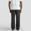 A person with tattoos stands wearing relaxed, faded cuffless track pants in charcoal grey, paired with a white t-shirt.