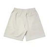 Light beige shorts with an elastic waistband and a small back pocket. Features a logo on the fabric.