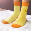 A pair of yellow and orange knitted socks featuring a zigzag pattern and a playful design.