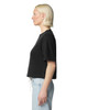 A black mid-length boxy top displayed on a model, showing a side view with short sleeves. The top has a logo.