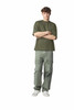 A model wears an olive-green oversized boxy top with light green cargo pants and white sneakers.