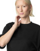 A black oversized boxy top with a crew neckline, featured on a model with short blonde hair.