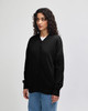 A black unisex bomber jacket with a zippered sleeve pocket, displayed on a model from the side.
