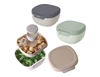 A set of four salad bowls in varying colours, featuring a compartmentalised design and a lid with a logo.