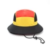 A panelled bucket hat in red, yellow, and black with a chin rope and a logo.