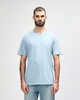 A light blue midweight T-shirt on a male model, featuring a crew neck and short sleeves. It includes a logo on the side.