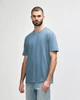 A light blue midweight t-shirt on a model, featuring a simple design and short sleeves. The shirt has a logo.