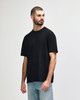 A black midweight t-shirt displayed on a model, featuring a simple design and a logo.