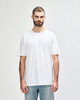 A plain white adult t-shirt is displayed on a model. The t-shirt features a logo and has a relaxed fit.