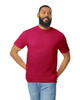 A man wearing a burgundy Gildan Softstyle adult T-shirt paired with blue jeans, smiling. The shirt features a logo.