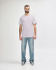 A light grey Gildan Softstyle adult t-shirt worn with blue jeans, featuring a logo on the t-shirt.
