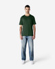 A green Gildan Softstyle adult T-shirt displayed on a model, paired with blue jeans and white shoes.
