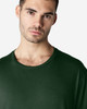 A green Gildan Softstyle adult T-shirt featuring a round neckline, modelled by a man.